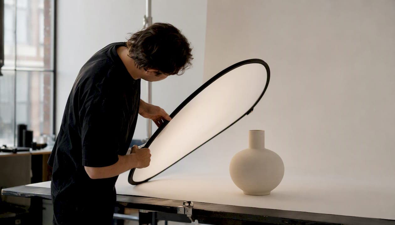 Photographer adjusting lighting for product photo shoot