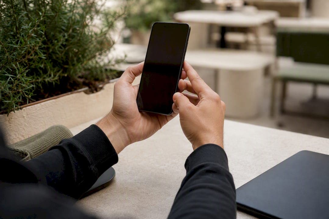 Close-up of hand holding phone vertically