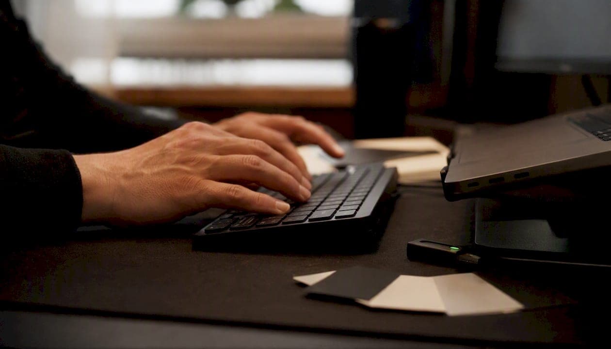 Developer hands typing with branding tokens nearby